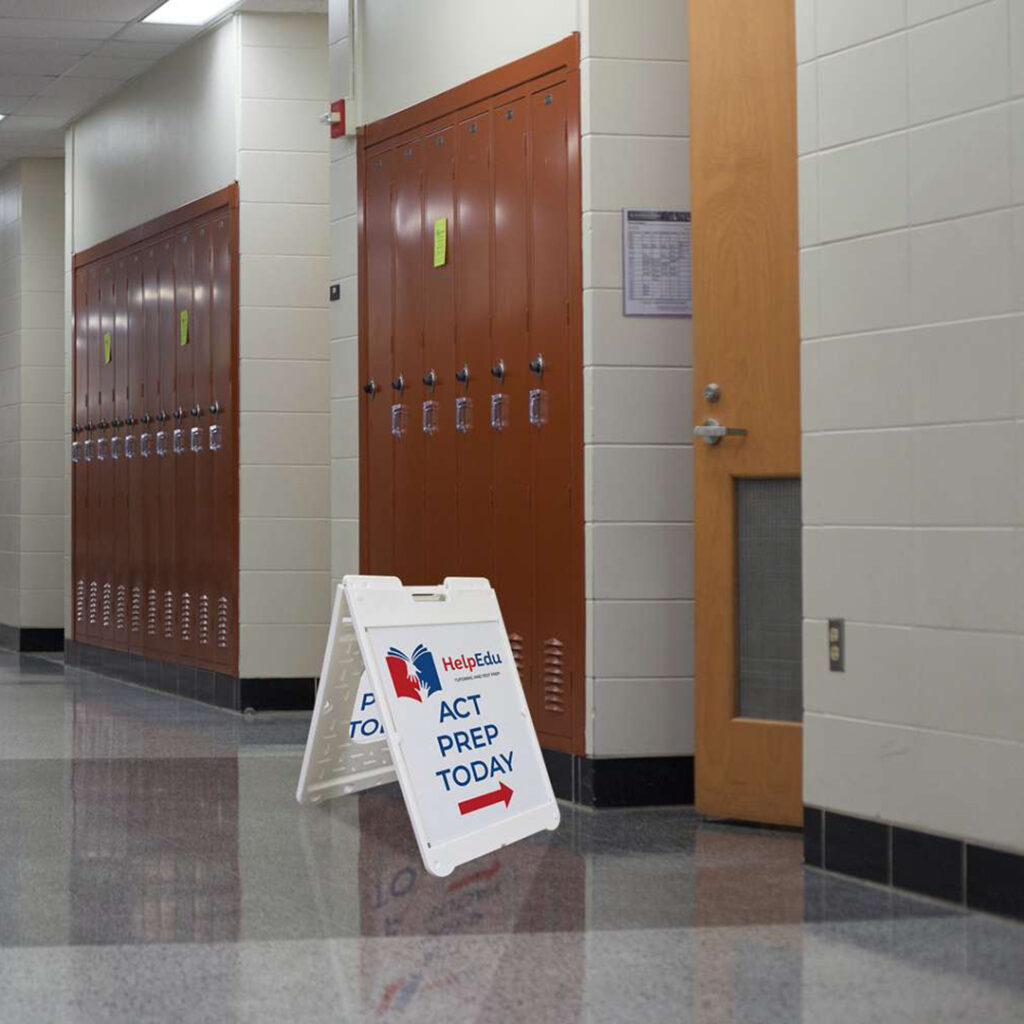 School hallway with brown lockers and a sandwich board sign reading 'HelpEdu ACT PREP TODAY' with an arrow pointing right.