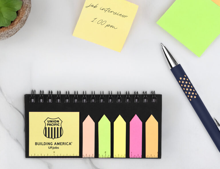 Union Pacific branded notepad with colorful sticky notes, a pen, and a yellow note reading ‘Job interview 1:00 pm’ on a white surface.