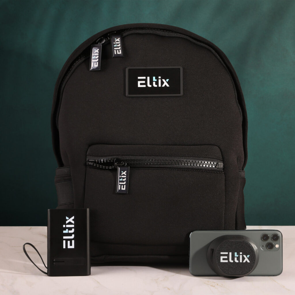 Black branded backpack with matching portable charger and a phone grip displayed in front, all featuring the Eltix logo against a dark green backdrop.