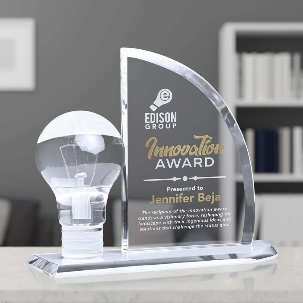 Crystal innovation award with a light‑bulb design displayed on a desk in a modern office setting.