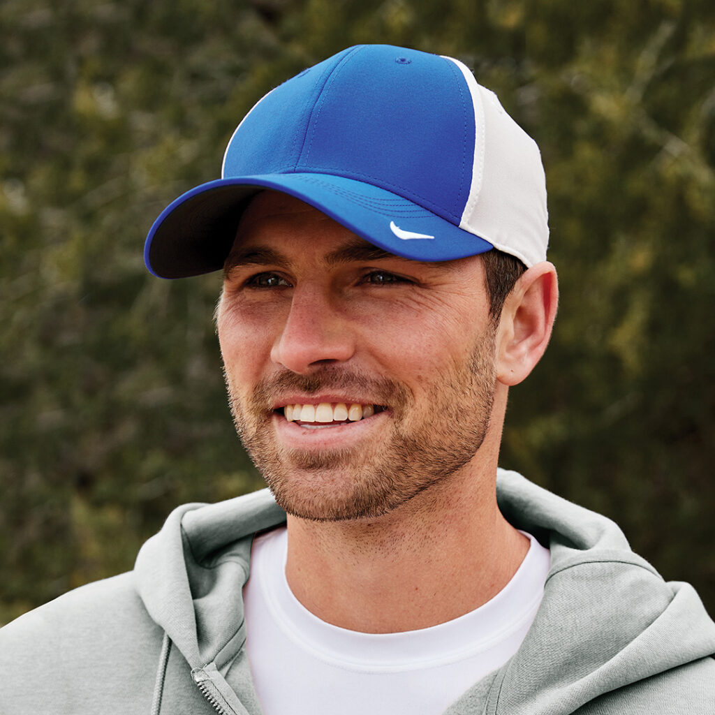 Person outdoors wearing a blue and white Nike baseball cap and a light hoodie.