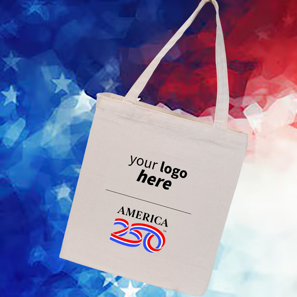 Canvas tote bag with “America 250” design and “your logo here” placeholder, displayed against a red, white, and blue star-pattern background.