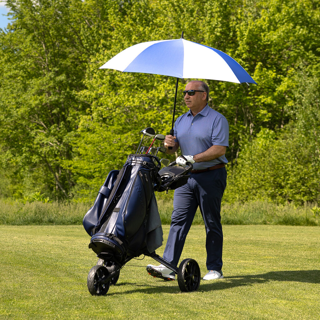 Custom golf umbrella used outdoors for sun protection during a round of golf