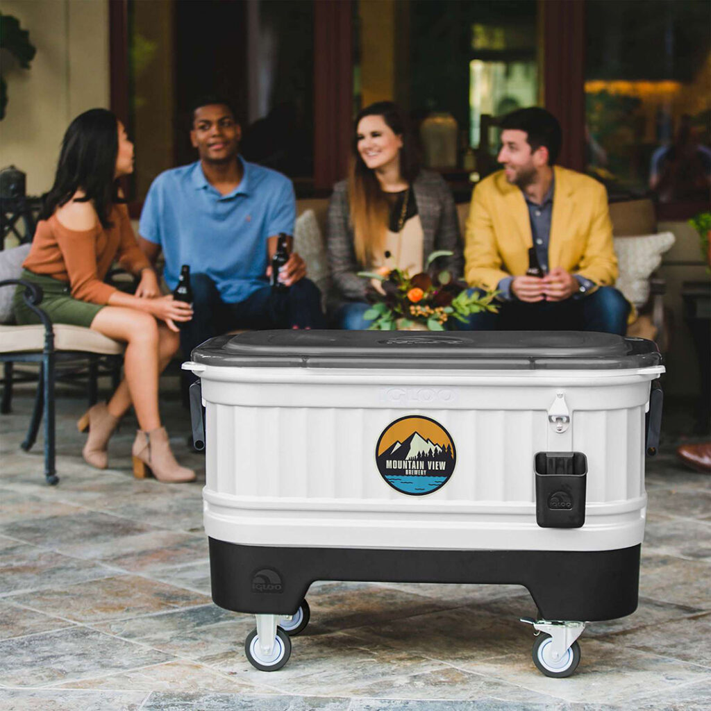 Custom-branded rolling cooler displayed at an outdoor gathering, providing cold beverage storage for tailgates, parties, and game-day events.