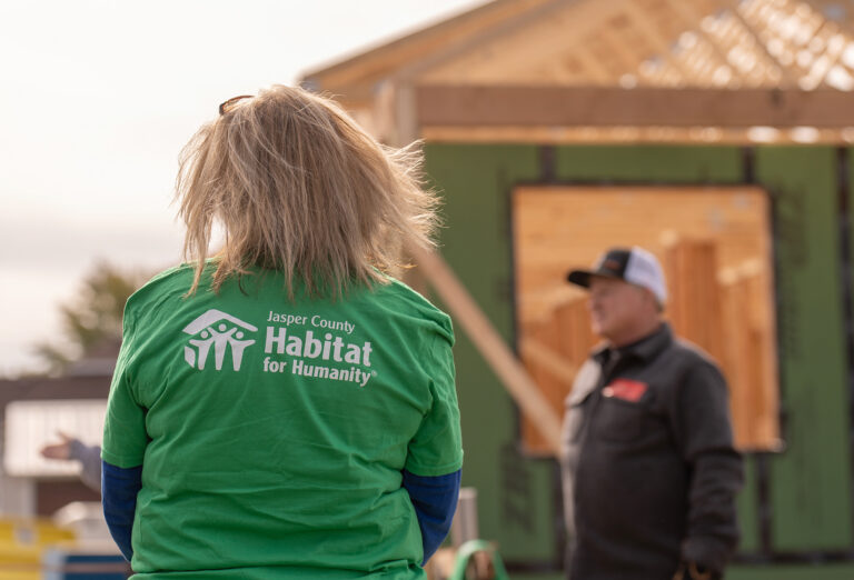 Habitat for Humanity volunteer wearing branded nonprofit apparel at a community build site.