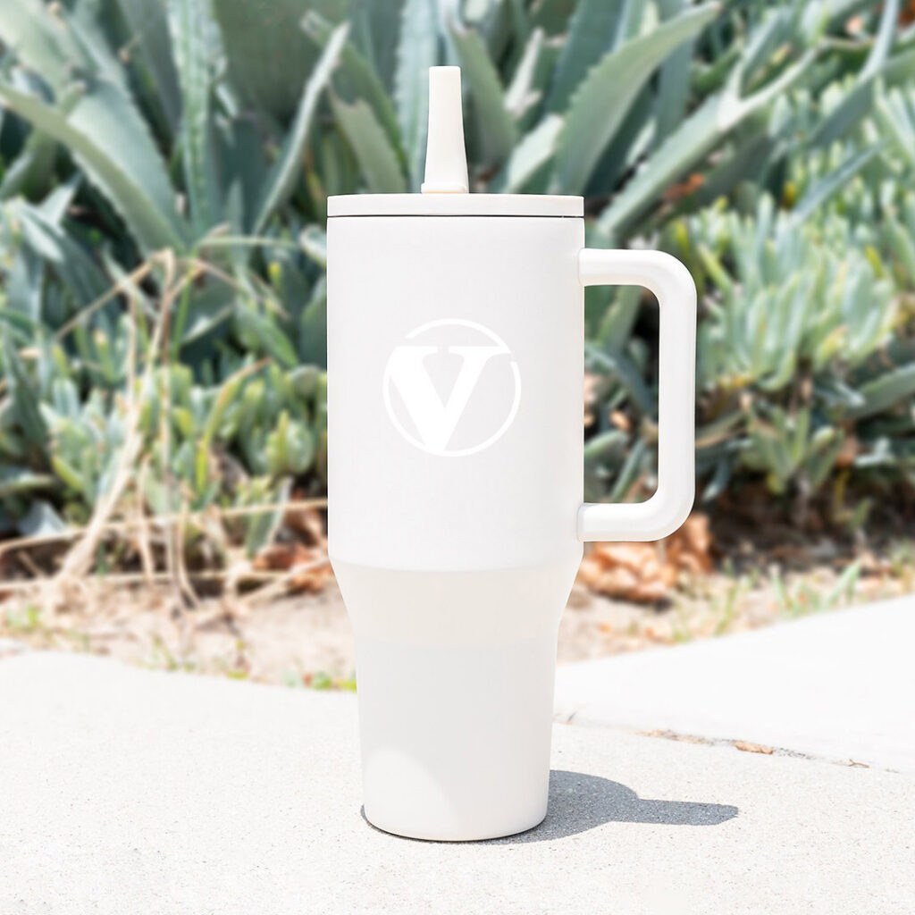 Branded insulated tumbler in a clean egret white shade displayed outdoors against natural greenery, demonstrating how timeless neutral colors can elevate Autumn/Winter 2026 branded drinkware collections.