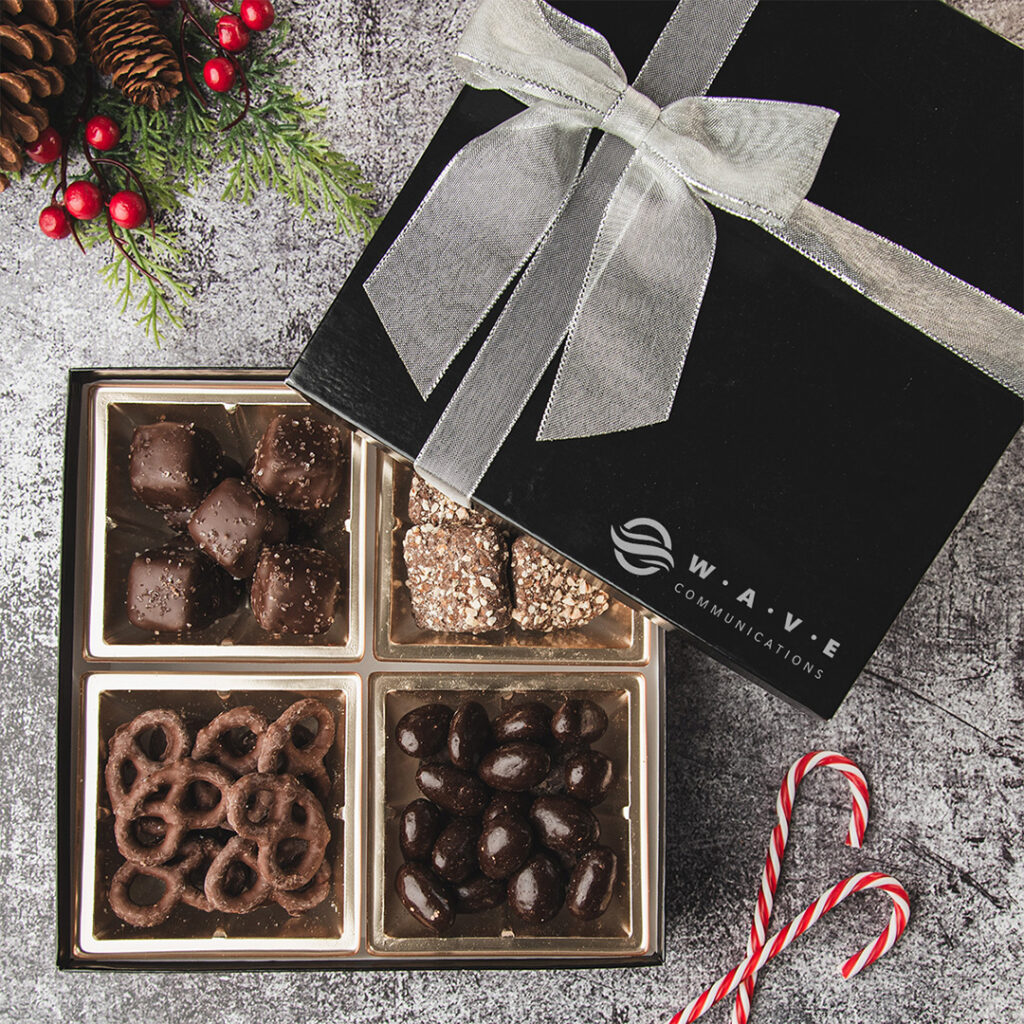 Custom-branded chocolate gift box with silver ribbon and logo printing, featuring compartmentalized treats in premium retail packaging.
