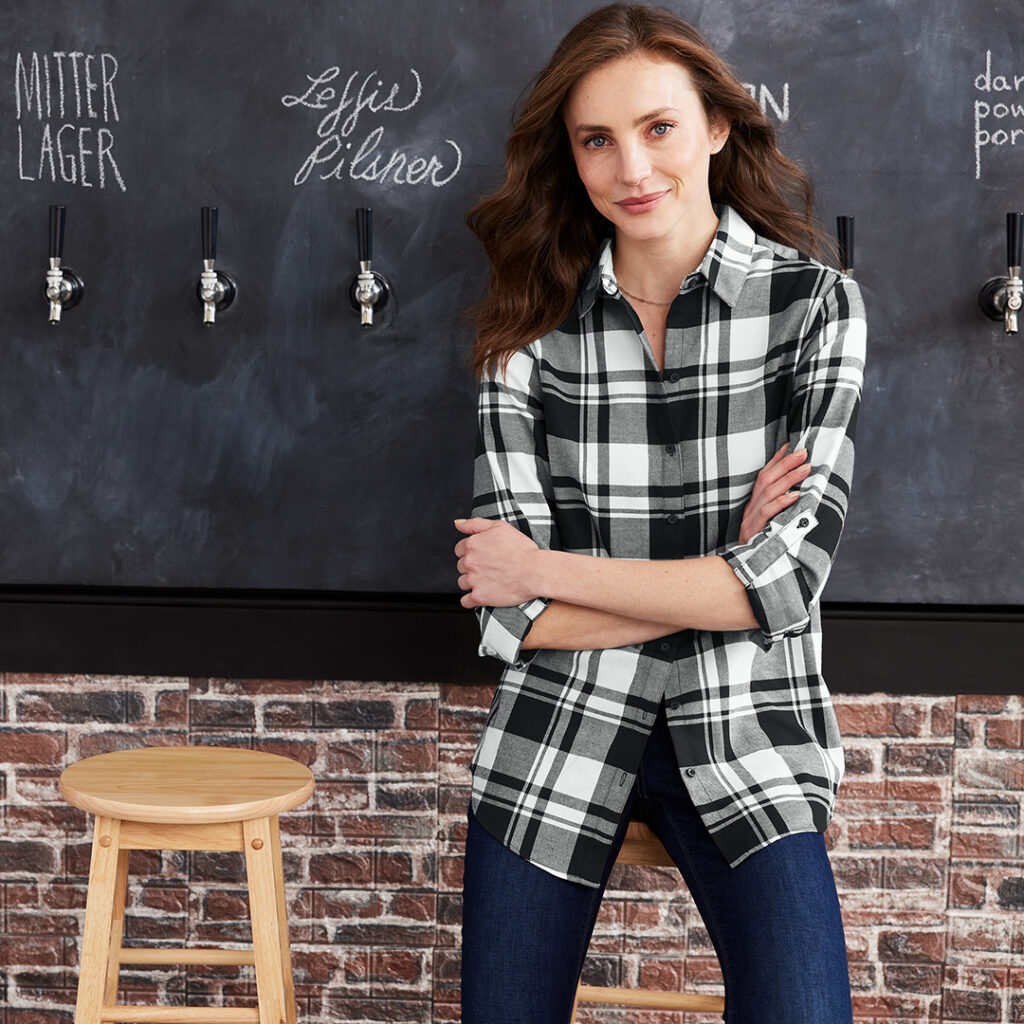 Black and white plaid button-down shirt showcased in a casual indoor setting.