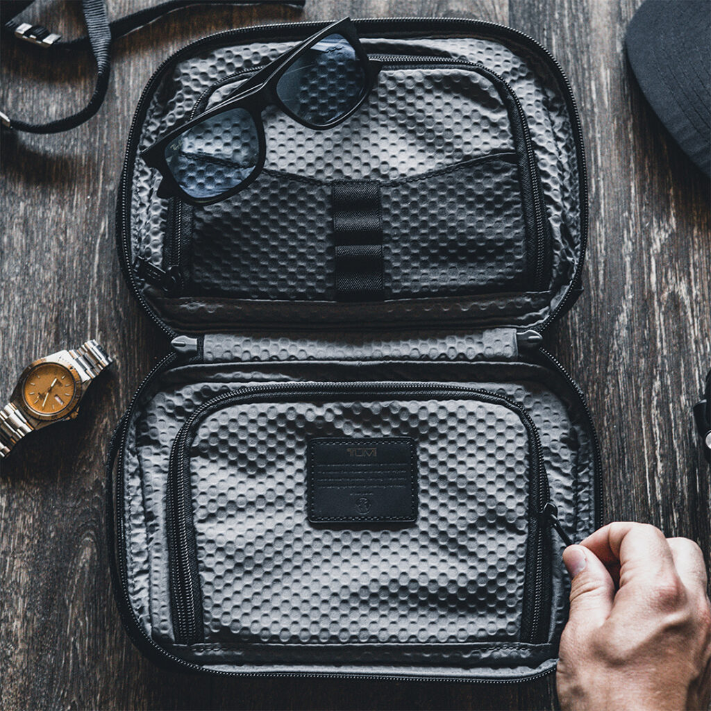Travel organizer case with compartments for accessories, sunglasses and a watch, highlighting a practical gift for frequent travelers and busy professionals.